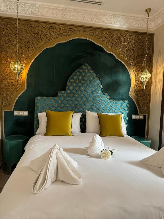 a bedroom with a large bed with a large headboard at Riad M'Barka in Tangier