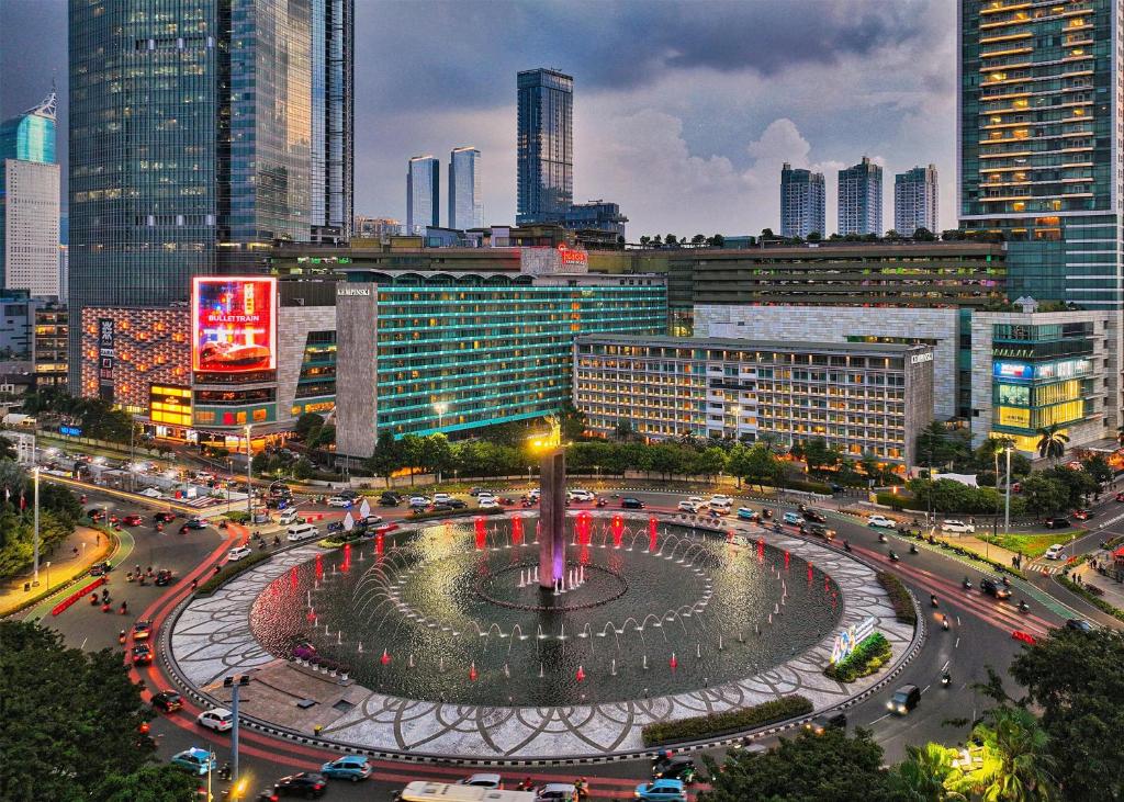 a city with a fountain in the middle of a city at Hotel Indonesia Kempinski Jakarta in Jakarta