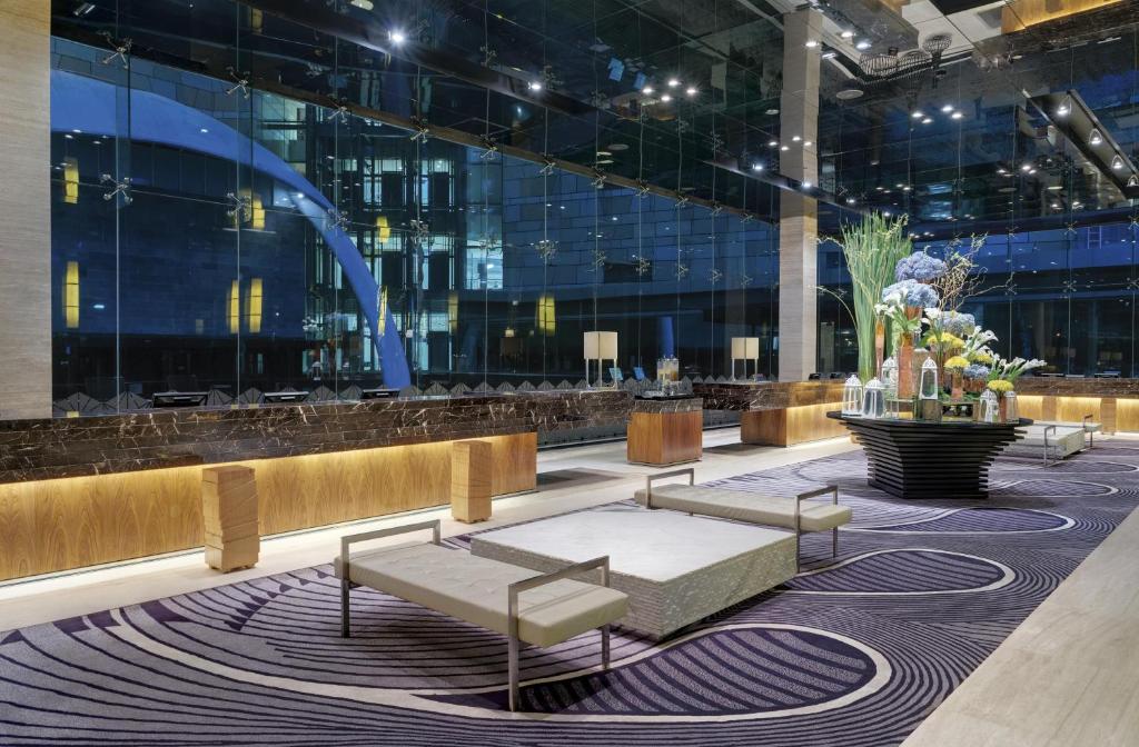 a lobby with benches and a table in a building at Hotel Indonesia Kempinski Jakarta in Jakarta