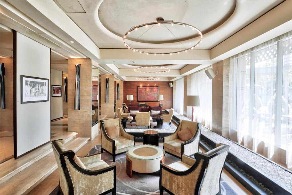 a lobby of a hotel with chairs and a chandelier at Hotel Indonesia Kempinski Jakarta in Jakarta