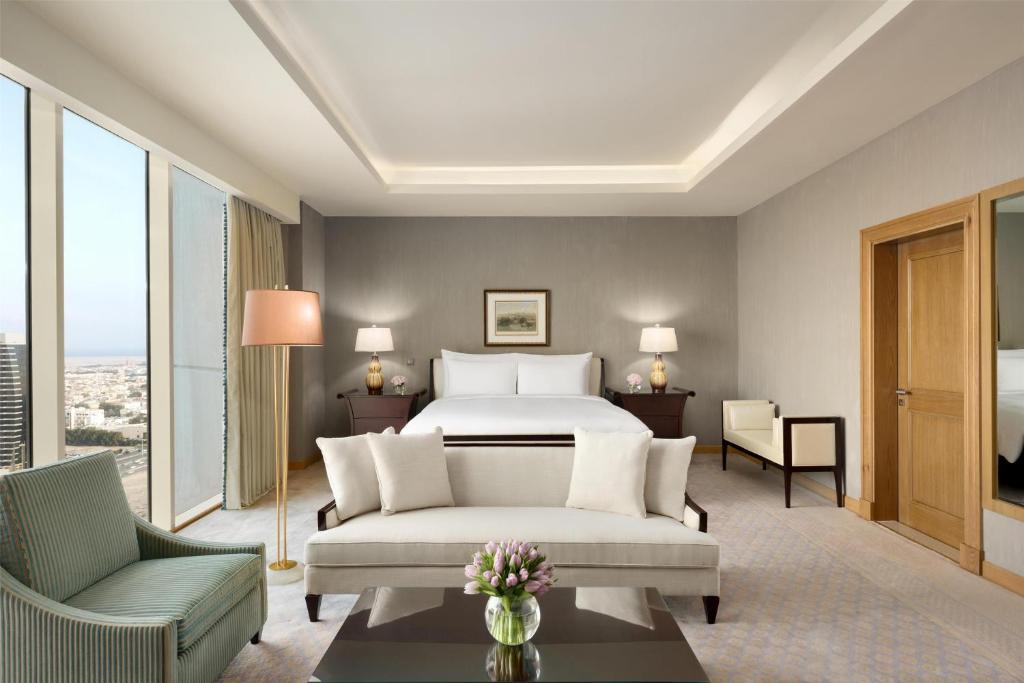 a hotel room with a bed and a couch at Kempinski Al Othman Hotel Al Khobar in Al Khobar