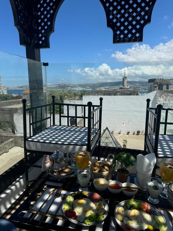 a table with food on it with a view of the water at Riad M'Barka in Tangier