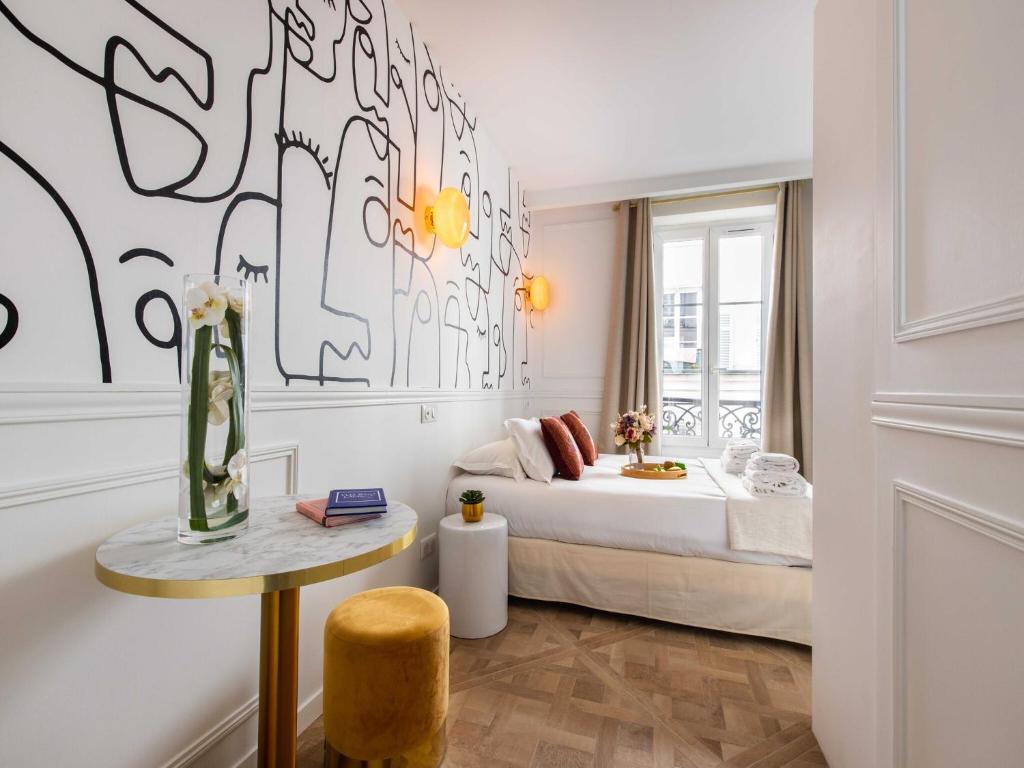 - une chambre avec un lit et une table avec un vase dans l'établissement Charming studio - 2P - Pigalle Sacré-C ur, à Paris