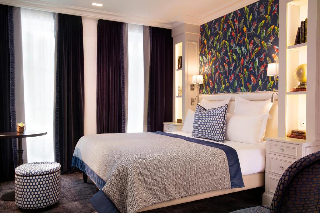 Un dormitorio con una cama y un cuadro en la pared. en Hotel Monge, en París