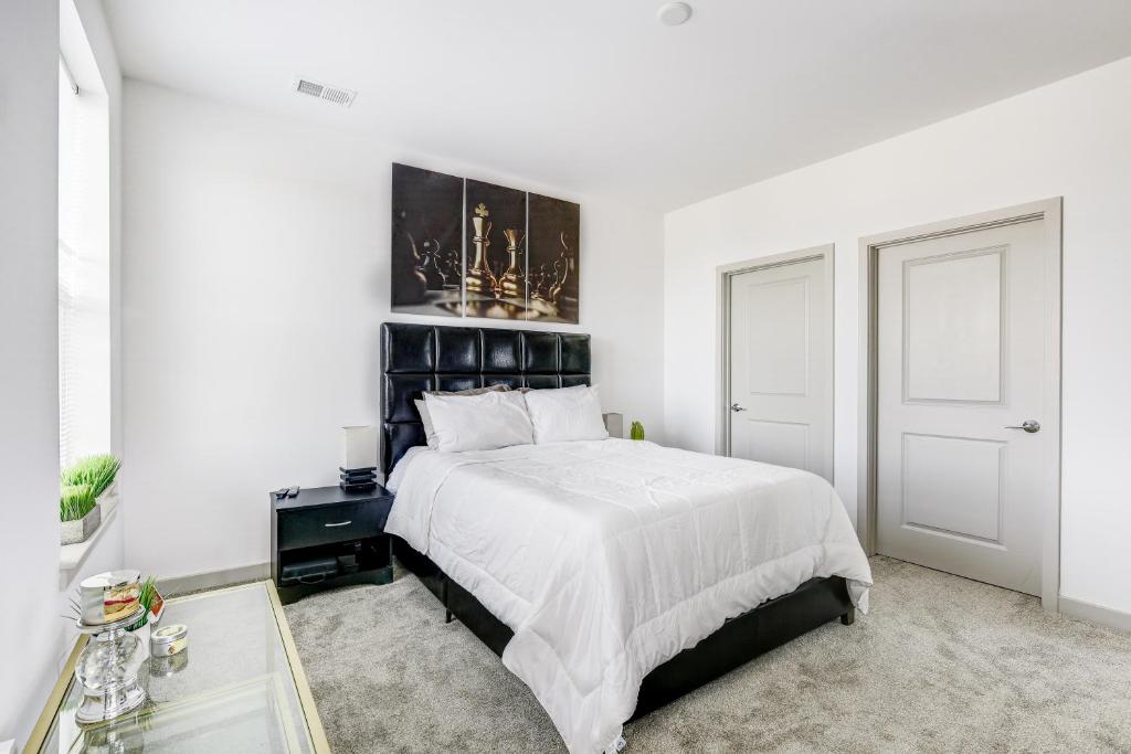 Un dormitorio blanco con una cama grande y una ventana. en Luxury Downtown Crown Apartment, en Gaithersburg