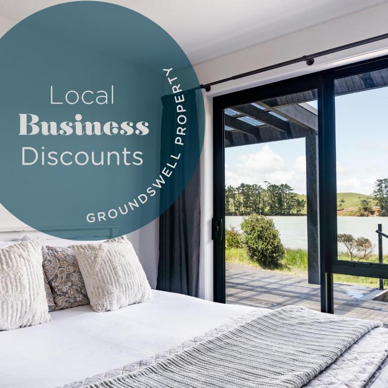 a bedroom with a bed with a view of the ocean at Kaitoke Retreat and Studio, 10 guests, Waterfront in Raglan