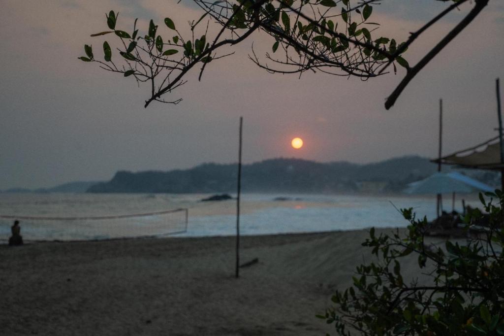 un tramonto su una spiaggia con una rete da pallavolo di Columpio del Reptil cabaña a Mazunte