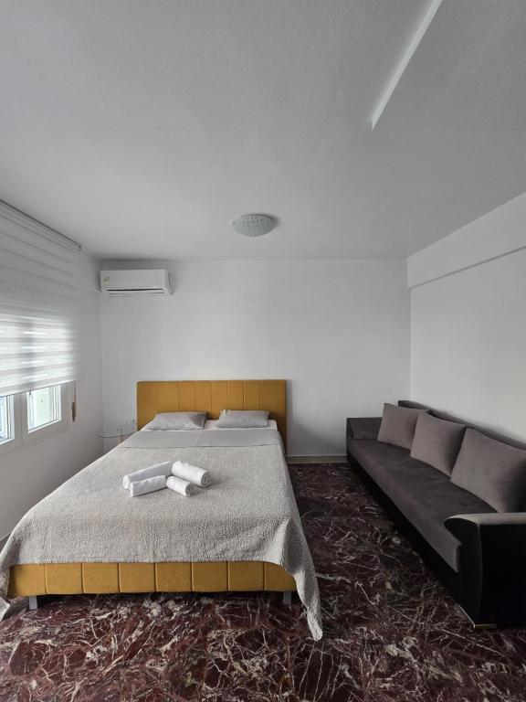 un dormitorio con una cama y un sofá en Luxury Angel Apartments 1, en Paralia Katerinis