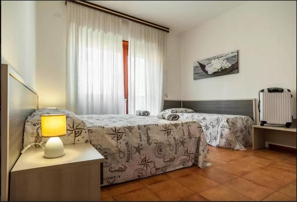 1 dormitorio con 2 camas y mesa con lámpara en House Via Manzoni, en Terracina