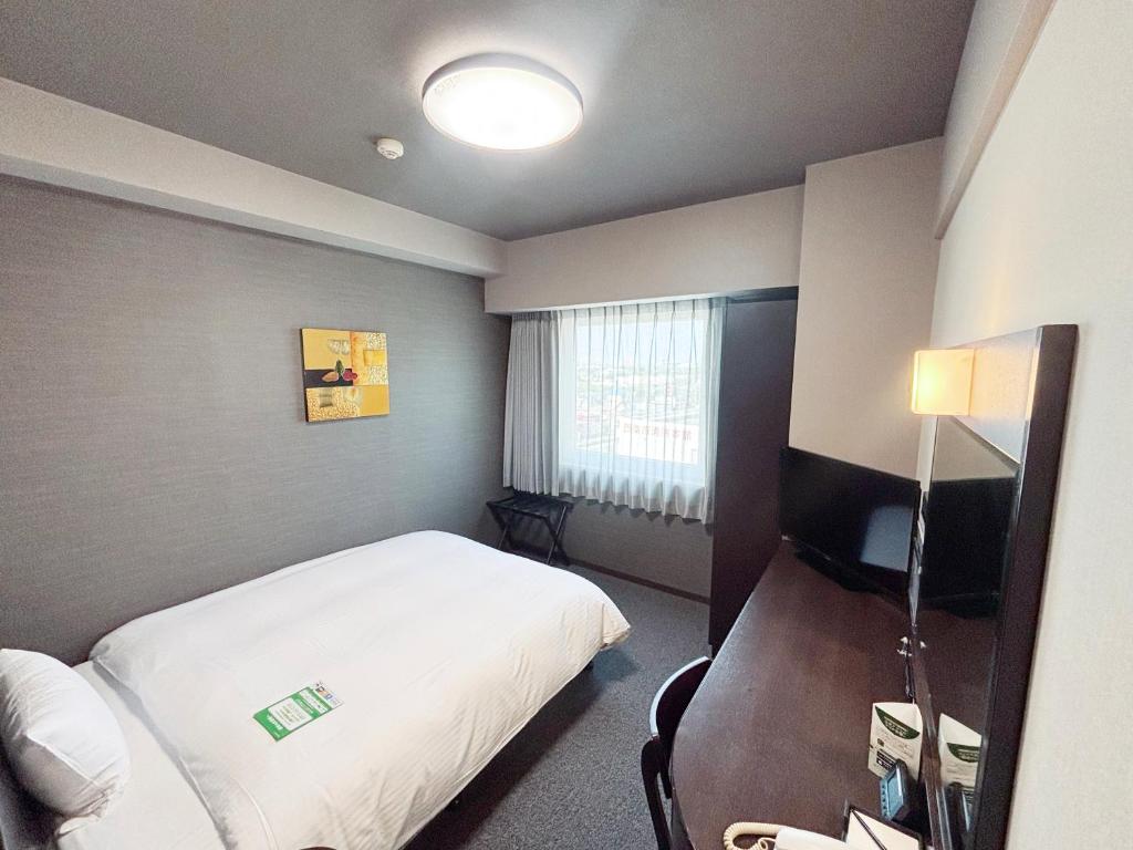 Postel nebo postele na pokoji v ubytování Hotel Route-Inn Iyo-Saijo