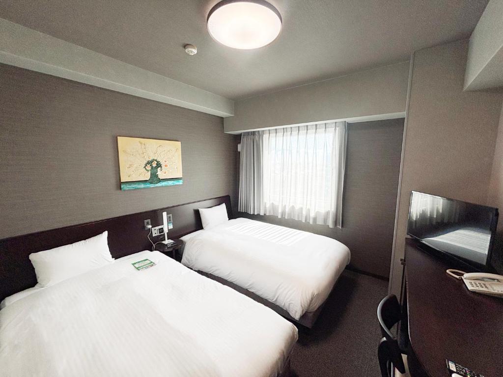 Postel nebo postele na pokoji v ubytování Hotel Route-Inn Iyo-Saijo