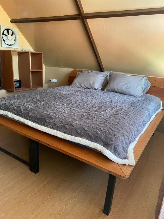 a large bed with a wooden frame in a bedroom at New Private Rooms in Haole Santa Fe in General Luna