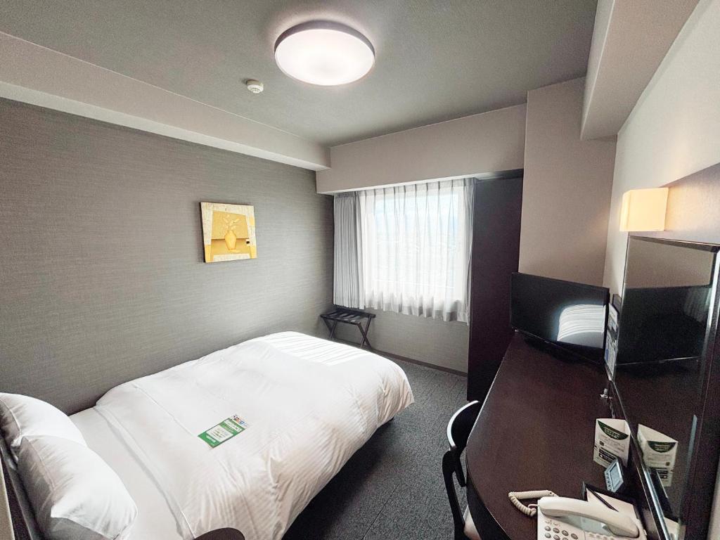 Postel nebo postele na pokoji v ubytování Hotel Route-Inn Iyo-Saijo