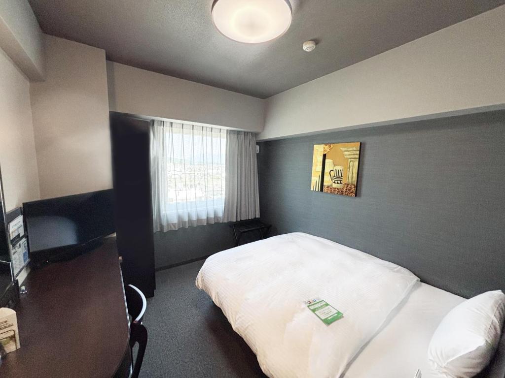 Postel nebo postele na pokoji v ubytování Hotel Route-Inn Iyo-Saijo