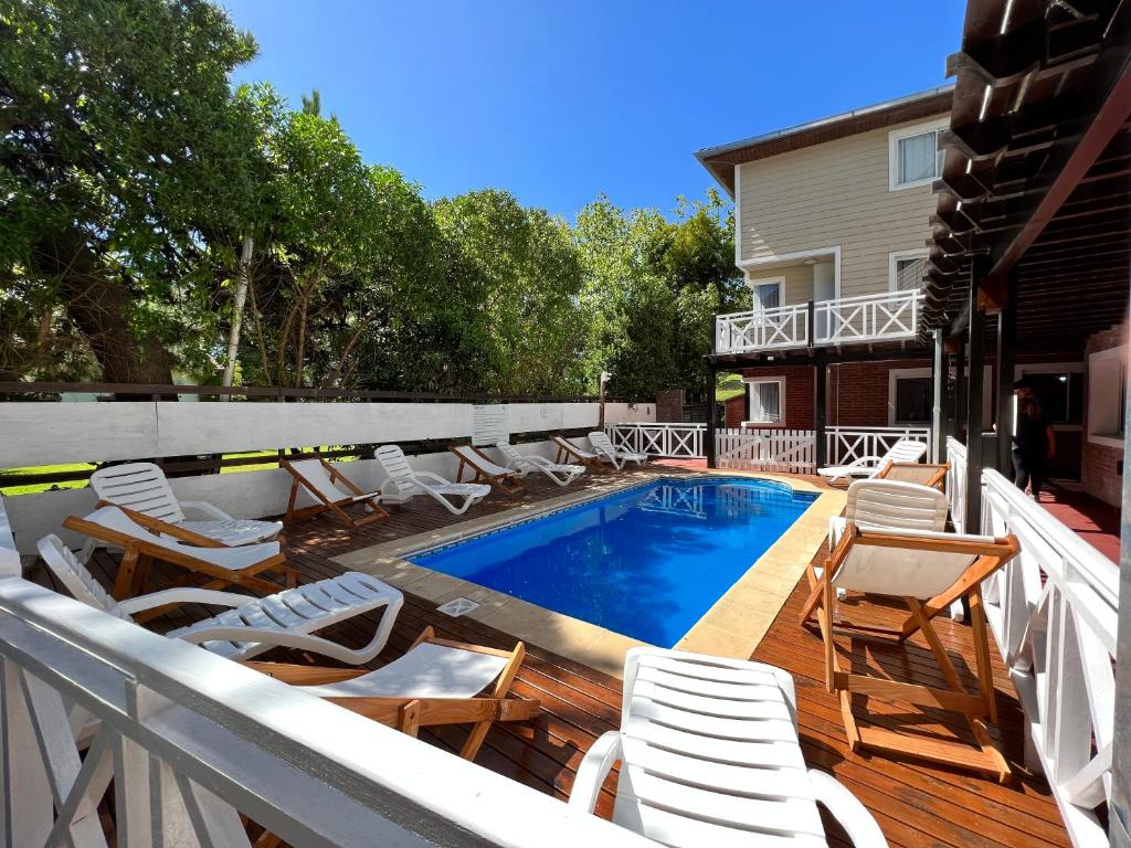 Una terraza con sillas y una piscina en una casa. en Valeria Costa y Mar, en Valeria del Mar