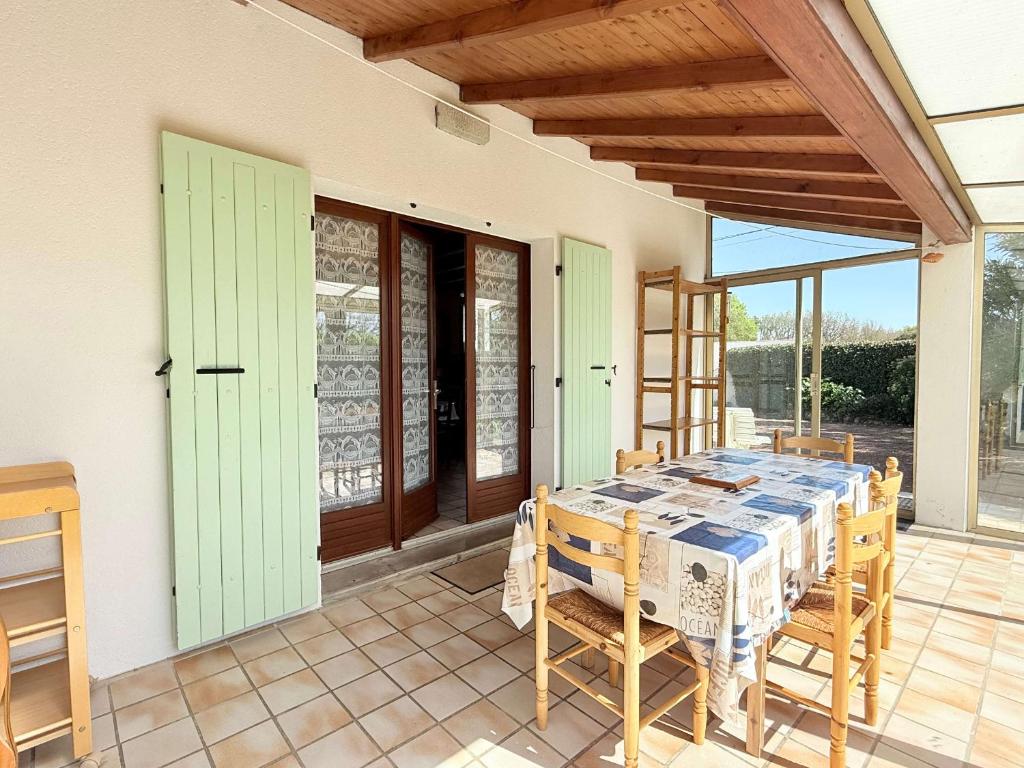 un patio avec une table et des chaises sur un porche dans l'établissement La Quiétude Oléronaise - Plage à 1.5km - 8 personnes - FR-1-778-49, à Dolus-d'Oléron