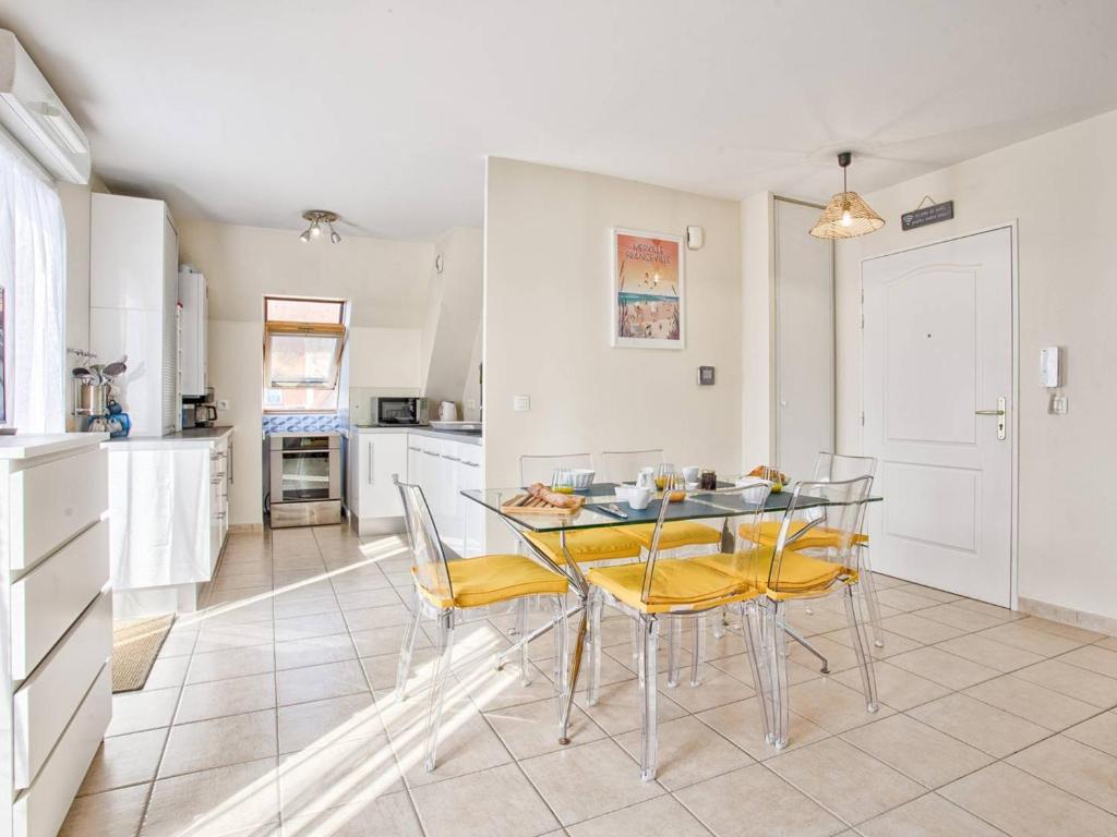 une cuisine et une salle à manger avec une table et des chaises dans l'établissement Appartement lumineux avec balcon et piscine pour 5 personnes - FR-1-788-67, à Merville-Franceville-Plage