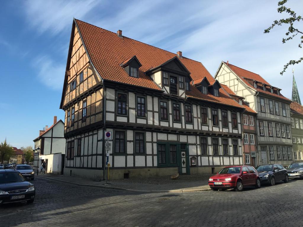 クヴェードリンブルクにあるKaufmannshaus Anno 1613の赤い車が目の前に停まっている建物