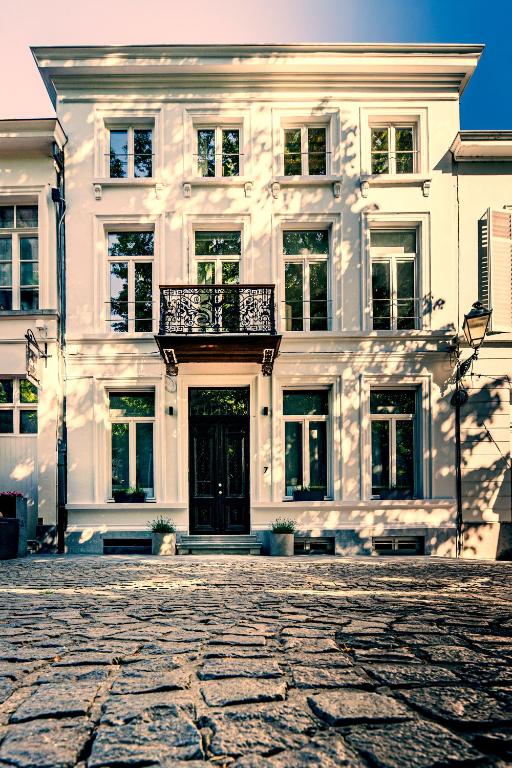 a large white building with a balcony in front of it at Maison Martin 7 in Kortrijk