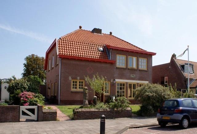 a house with a car parked in front of it at Amsterdam Beach Apartment in Zandvoort