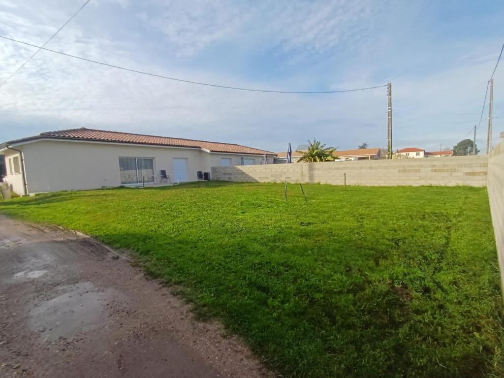 une maison avec un champ vert à côté d'une route dans l'établissement Maison caroline 1, à La Celle-sous-Gouzon