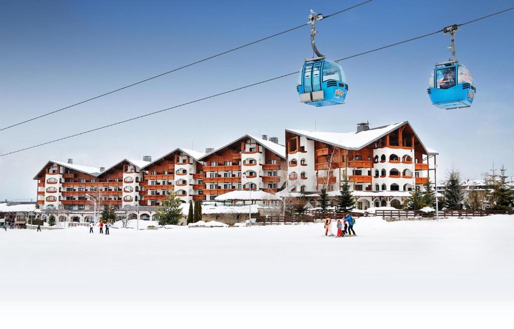 a ski lodge in the snow with a ski lift at Kempinski Hotel Grand Arena Bansko in Bansko