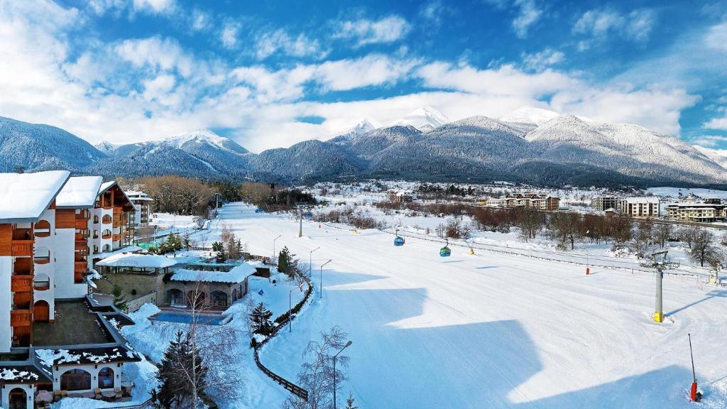 a snow covered ski slope with mountains in the background at Kempinski Hotel Grand Arena Bansko in Bansko