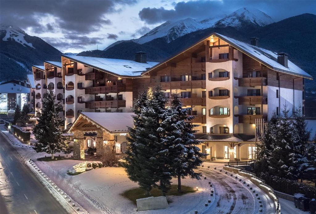 a hotel in the mountains with snow on the ground at Kempinski Hotel Grand Arena Bansko in Bansko