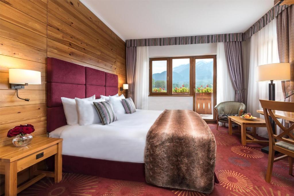 a hotel room with a large bed and a desk at Kempinski Hotel Grand Arena Bansko in Bansko
