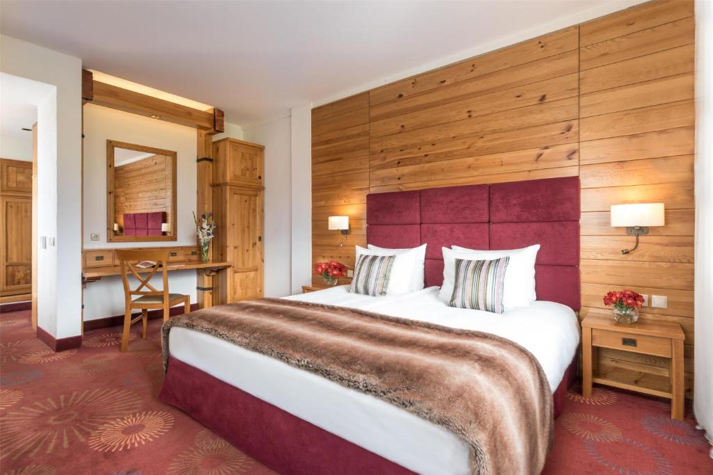 a hotel room with a large bed and a desk at Kempinski Hotel Grand Arena Bansko in Bansko