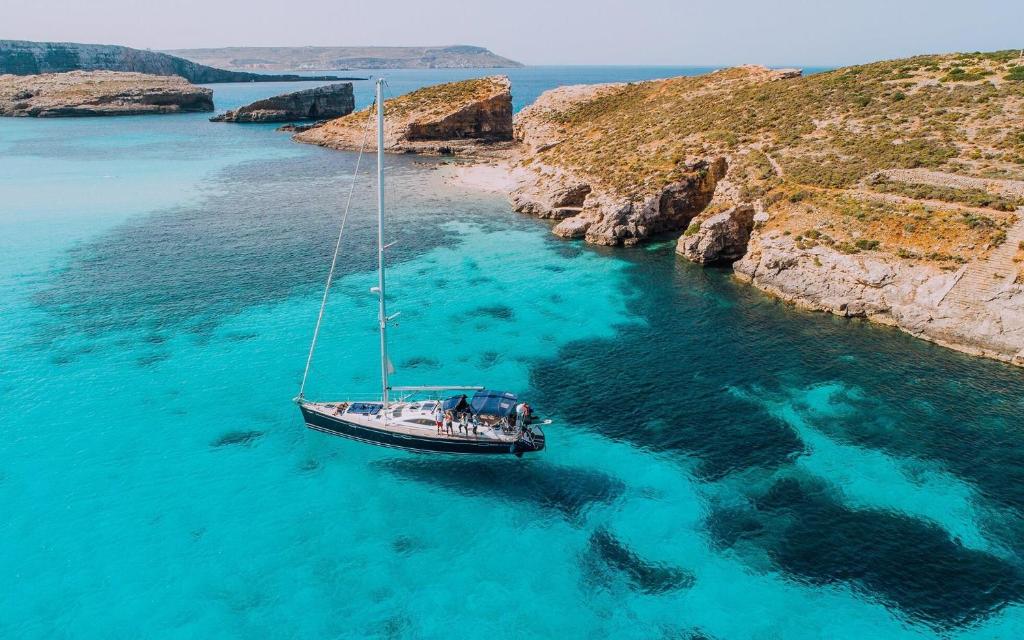 a boat floating in a body of water at Kempinski Hotel San Lawrenz in San Lawrenz