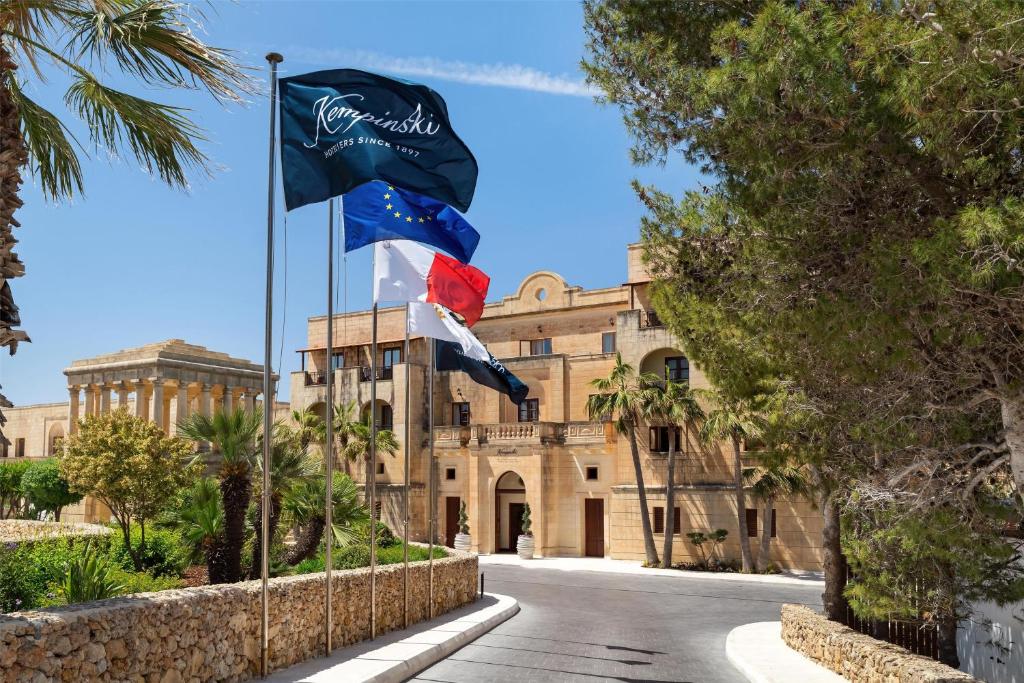 two flags flying in front of a building at Kempinski Hotel San Lawrenz in San Lawrenz