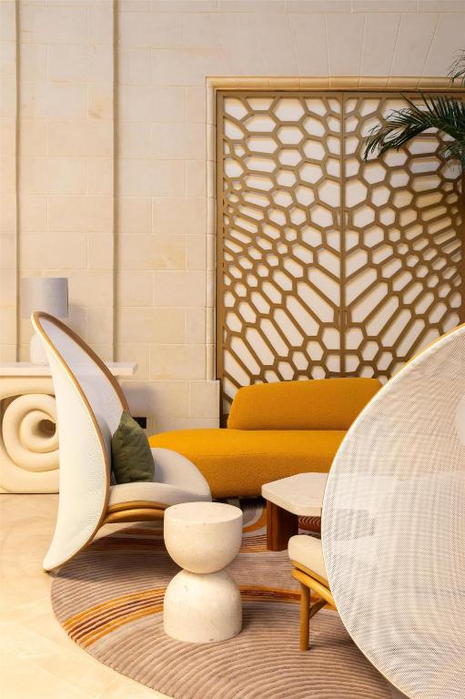 a living room with a couch and a chair at Kempinski Hotel San Lawrenz in San Lawrenz