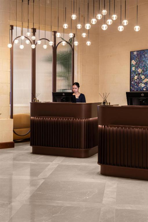 a man sitting at a reception desk in a lobby at Kempinski Hotel San Lawrenz in San Lawrenz