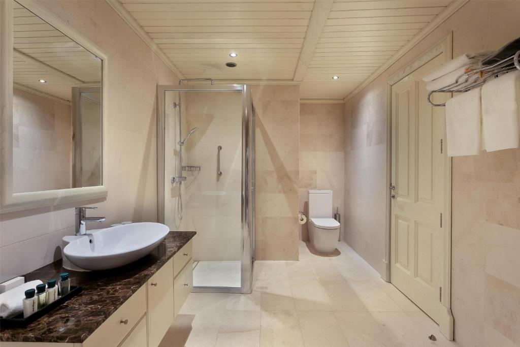 a bathroom with a sink and a shower and a toilet at Kempinski Hotel San Lawrenz in San Lawrenz