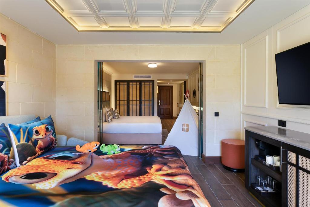 a living room with a bedroom with a bed and a fish rug at Kempinski Hotel San Lawrenz in San Lawrenz