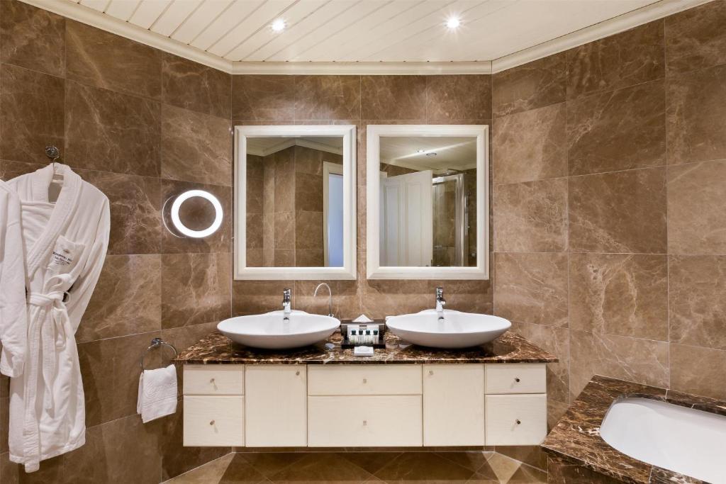 a bathroom with two sinks and a tub at Kempinski Hotel San Lawrenz in San Lawrenz