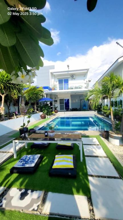 a villa with a swimming pool and a house at The beach house, Baroro Beachfront Villa in Bacnotan