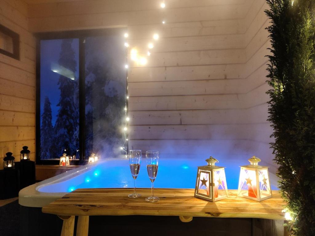 Un jacuzzi con copas de vino y velas. en Villa Huikonen, en Syöte