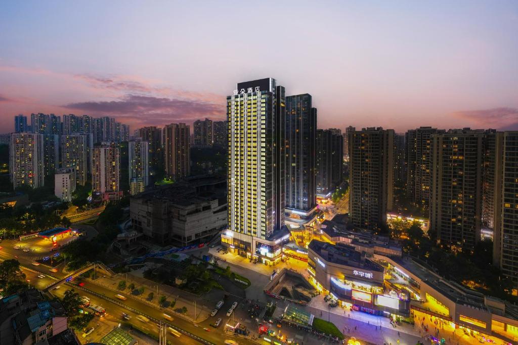 重慶市にあるAtour Hotel Chongqing West Railway Station Xinqiao Hospitalの高層ビルが立ち並ぶ夜の街並み