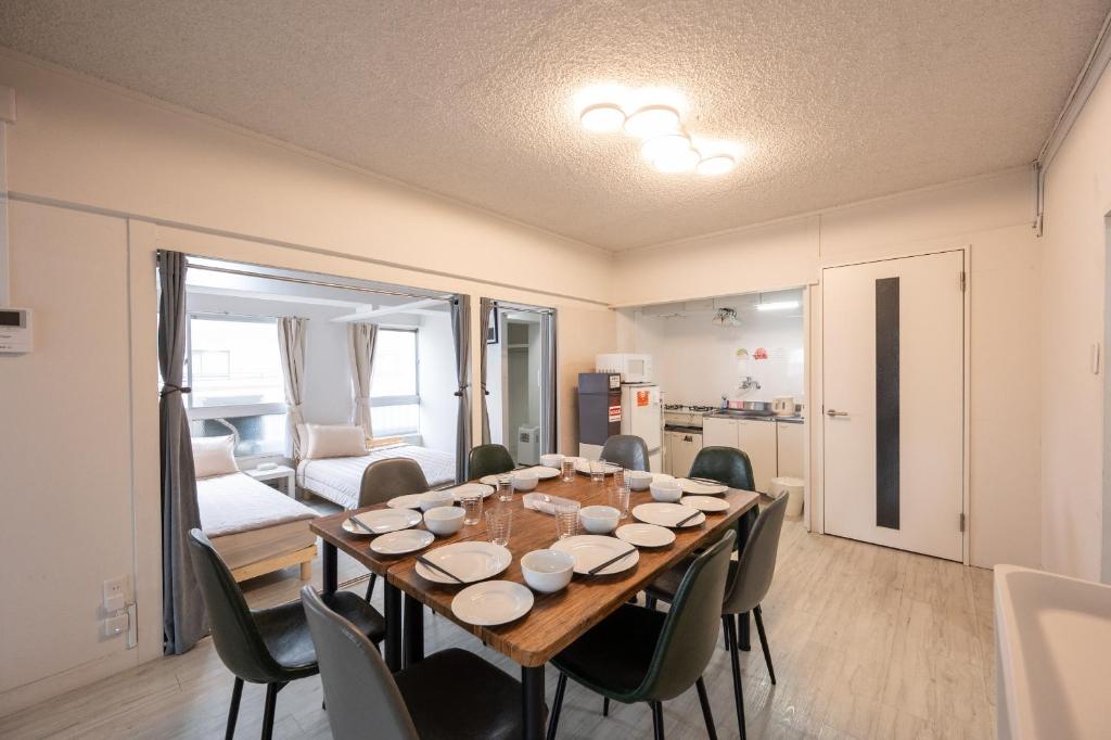 a dining room with a wooden table and chairs at GoodStay401 in Kurume