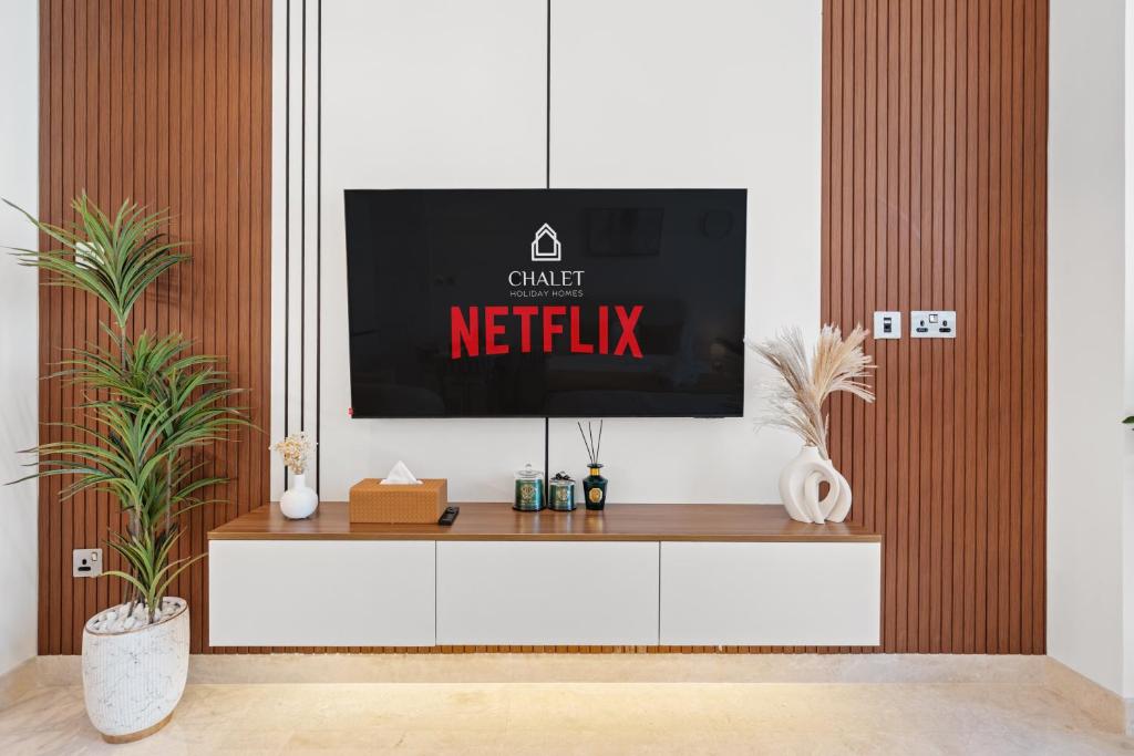 einen TV auf einem TV-Stand im Wohnzimmer in der Unterkunft Chalet Homes - LUX New Studio With 2 Double Beds in Downtown Dubai in Dubai