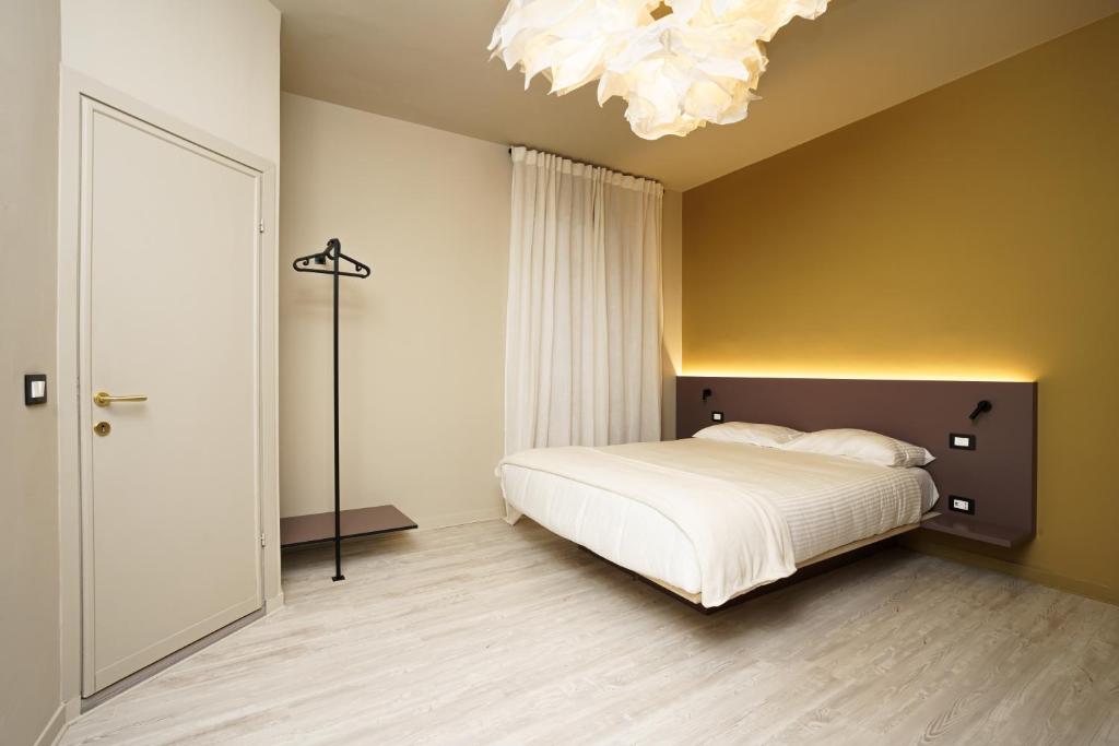 a bedroom with a white bed and a chandelier at Mario house Assisi in Assisi