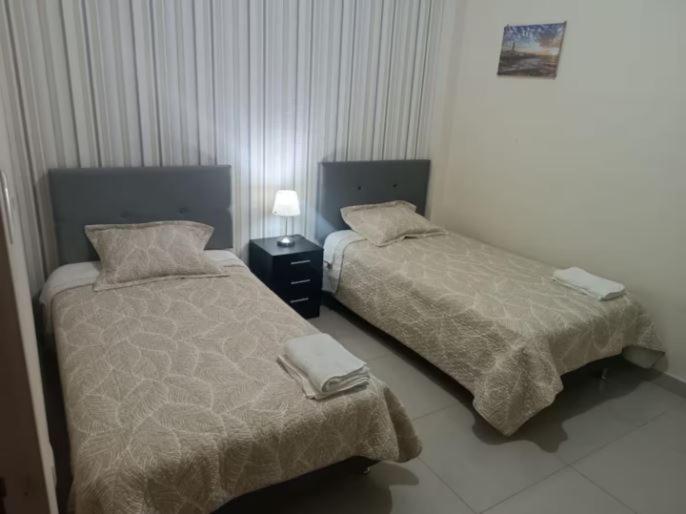 deux lits côte à côte dans une chambre dans l'établissement Departamento céntrico en un 1er piso en Huancayo, à Huancayo