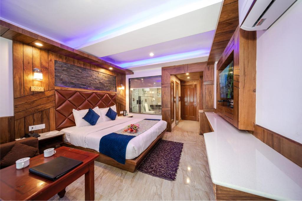 una camera da letto con un letto, una scrivania e una TV di Hotel Monal a Manāli