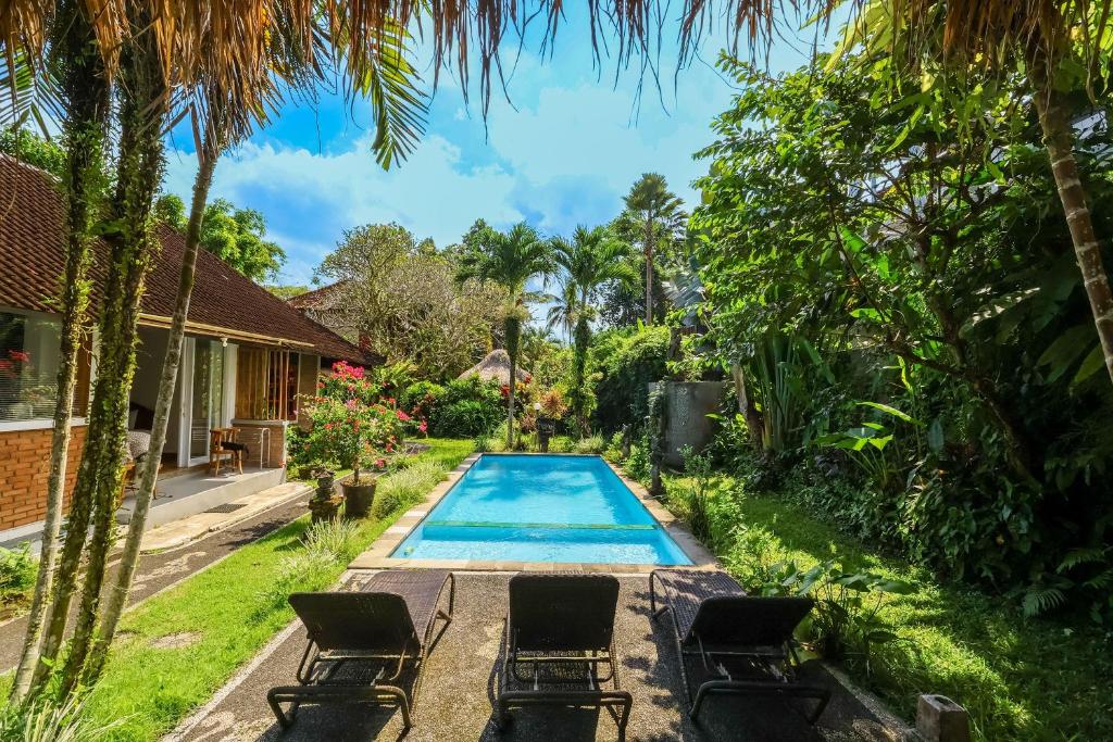 a swimming pool in the backyard of a house at Taman Lituhayu Cottages Ubud in Ubud