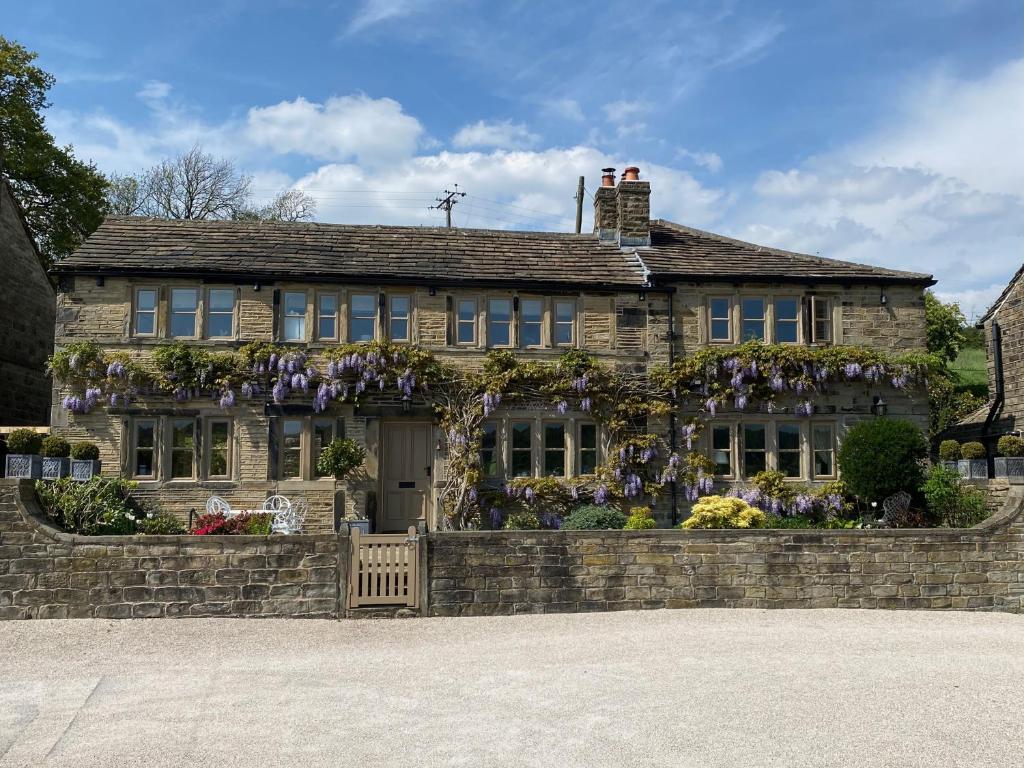 ein Haus mit Blumen an der Vorderseite in der Unterkunft Woodlea Cottage in Huddersfield