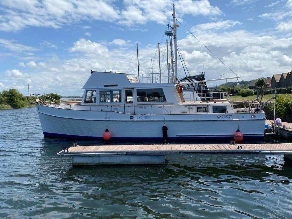 un bateau bleu garé à un quai dans l'eau dans l'établissement Nuit insolite a bord d un bateau, à Caen