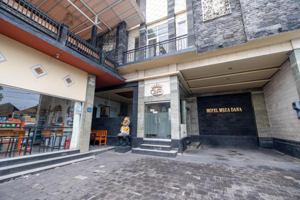 a building with a brick walkway in front of a store at Hotel Mega Dana in Kesiman