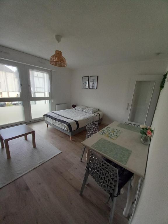 Cette petite chambre dispose d'un lit, d'une table et d'un sidx de table. dans l'établissement Appartement rénové et équipé, à Saint-Jacques-de-la-Lande